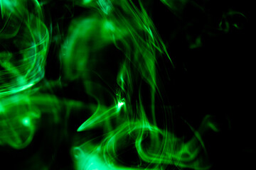 An abstract photograph of light green smoke on a black background. Creative smoke photography design.