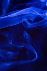 Lovely shape of blue smoke on a dark background. abstract smoke photograph. Wallpaper and background creative design.