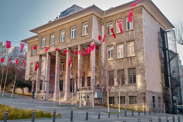 istanbul turkey 03.03.2021. Ancient roman columns and baroque architecture building in Beyoglu istanbul covered by Turkish flag and cobblestones street. Finance building in istanbul in morning.