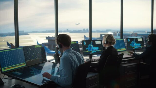 Diverse Air Traffic Control Team Working in a Modern Airport Tower. Office Room is Full of Desktop Computer Displays with Navigation Screens, Airplane Departure and Arrival Data for Controllers.