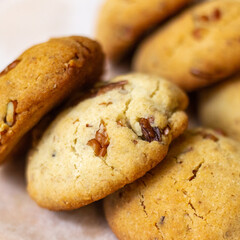 front shot of several vegan chochochip cookies on top of each other. brown chocolate chip cookies.