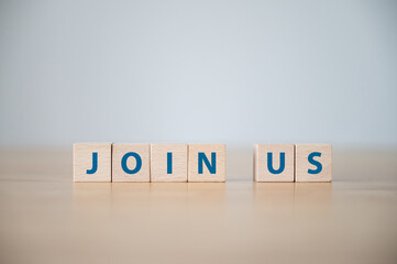Join us concept. The word on wooden block on wood table with copy space