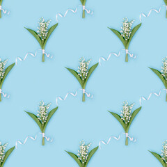 Pattern from delicate spring flowers blooming white lily of the valley on blue. Spring floral conceptual image.