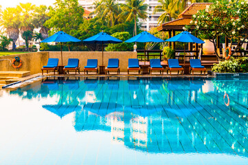 Beautiful umbrella and chair around swimming pool in hotel and resort