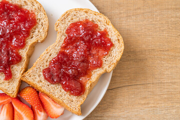 whole wheat bread with strawberry jam and fresh strawberry
