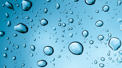 Water drops on a clear Glass. Wet surface. Rainy cloudy day. Raindrops on glass. Water splash or dew on a window. Cloudy blue sky. Super macro photo background. 