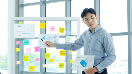 Businessman presenting business plan information at office meeting, Asian man explaning business...
