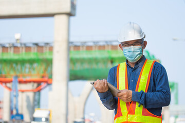 Asian man Senior Engineer expert professional use tablet work on site construction, Then man wera face mask protect coronavirus covid19 ,PM2.5