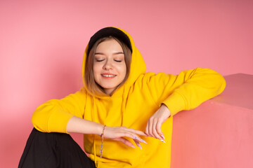 Girl in yellow hoodie and black cap