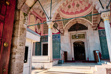 Hatice Turhan Sultan tomb in istanbul. Gate opens to garden inside tomb building. Arabic, turquoise color ottoman glazed tile details on gate and ottoman style architecture. Turkey istanbul 04.03.2021