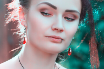 Portrait of a beautiful young woman with red jewelry