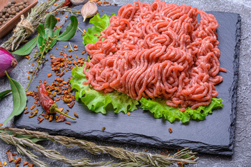Fresh minced pork and beef, garnished with garlic, red pepper and dill on a slate stone.Dark...