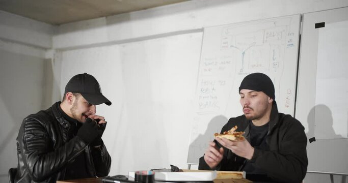 Criminals at work eating pizza