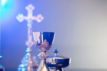 Religion theme – Easter. Catholic symbols composition. The Cross, monstrance  and golden chalice on blue background. 