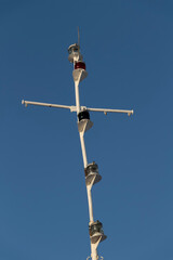 The mast of a modern ship against the background of the blue sky.