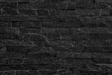 Black stone wall background. old stucco black and aged paint brick wall background design.