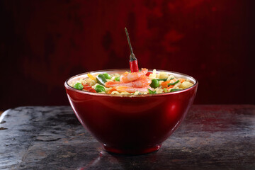 Chinese noodles with red pepper on black background