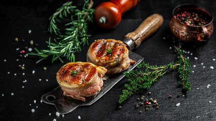 Medallions steaks from the beef tenderloin covered bacon on old meat butcher on Dark background....