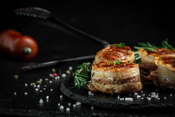 Grilled steak filet mignon wrapped bacon dark concrete background. banner, menu recipe place for...