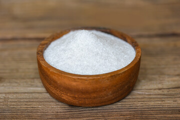 Monosodium glutamate on wooden bowl on the table background, MSG for food seasoning