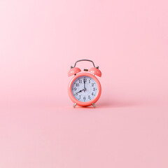 Pink alarm clock on a pink background. Copy space.