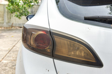 close up of white car taillight with old and dark color, old dark smoke light of car taillight not bright