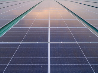 Solar panels or solar cells on the rooftop of factory industry building. Power plant in urban city, renewable energy source. Eco technology for electric power. © tampatra