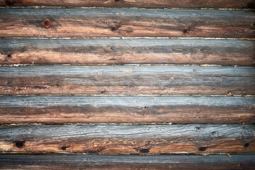 An old log wall of a rustic building with a texture. Wooden background.