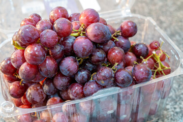 画面アップの買ってきたばかりのプラスチックのケースに入ったブドウ