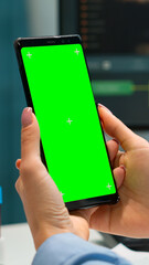 Professional chemist checking patient results on smartphone with green screen while coworker in white coat bringing blood samples. Scientist in lab using smartphone with mockup chroma key display