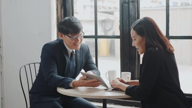 Happy two young businessman and woman shaking hands after successful meeting or negotiation with digital tablet sitting on desk cafe, Businesspeople discussion and smile lunch
