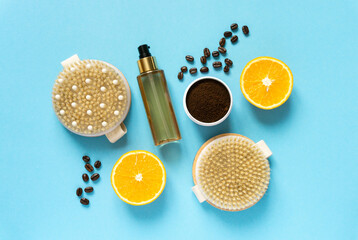 Set of various anti-cellulite care products. Dry massage brushes, coffee scrub and oil on blue background, top view