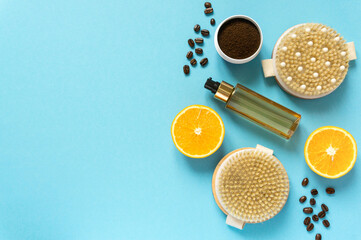 Set of various anti-cellulite care products. Dry massage brushes, coffee scrub and oil on blue background, copyspace