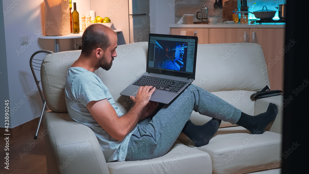 Poster professional game developer working on gameplay and game level late at night from the confort of his