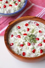 Pomegranate and Cucumber Raita. Indian Fresh sauce or condiment called Raita. Yogurt mixed with grated cucumber, onions, pomegranate, and spices. Garnished with fresh coriander. Copy space.