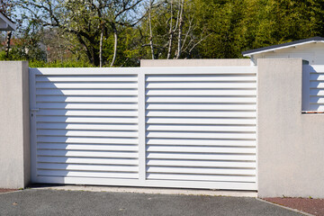 Fototapeta na wymiar steel white slide gate aluminum portal with blades of suburban house