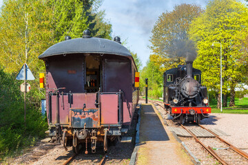 Railway station with a steam locomotive and passenger carriages
