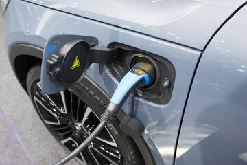 Close up view of vehicle electric charging socket plug in to recharge in Bangkok, Thailand.