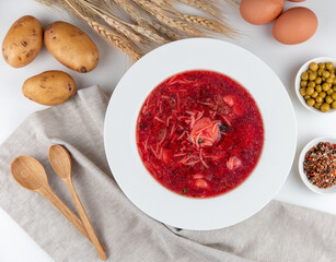 Top view of beetroot soup, eggs, spoon and potatoes