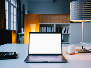 Laptop steht auf einem Schreibtisch mit weißem Bildschirm