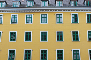 Yellow urban building façade with green windows