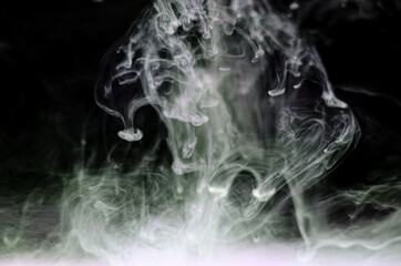 Ink swirls underwater. Ink cloud isolated on black background. Abstract effect of explosion of cosmos universe smoke with particles.