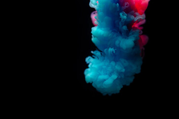 Multi-colored paints in water. Ink swirls underwater. A cloud of collision of bright ink on a black background. Colorful abstract explosion of smoke. Abstract background