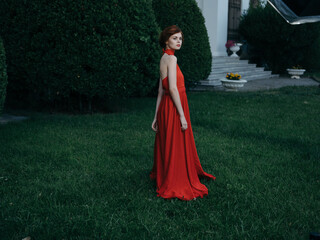 Woman in luxury red dress walk outdoors Masquerade gothic style