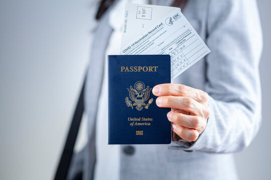 Clarksburg, MD, USA 03-29-2021: A Caucasian Businesswoman Is Showing Her Travel Documents At Airport Including US Passport, Boarding Pass And COVID Vaccination Record Card As A Proof Of Immunization.