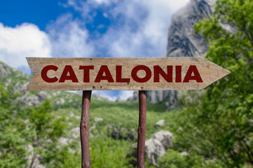 Catalonia wooden arrow road sign against mountain valley background. Travel to Catalonia concept.