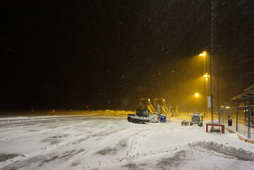Snow falling heavy on an airport in middle of night