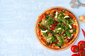 Fresh pizza with herbs and sun dried tomatoes on gray table
