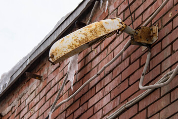 An old rusty street lamp attached to the wall.