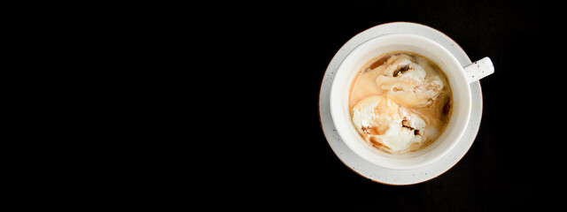 Coffee with ice cream close up shot. Over black background.